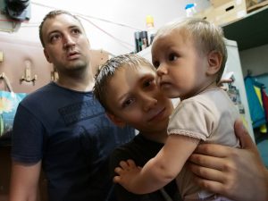 18 июля 2016 года. Щербинка. Денис Слободинский и его дети Юра и Настя (на руках) ждут, когда их расселят из коммуналки в новый дом. Фото: Александр Корнеев.