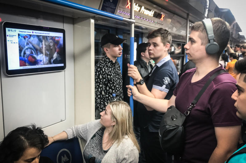 Пассажиры столичного метро смотрят матчи Чемпионата мира по футболу. Фото: Павел Волков