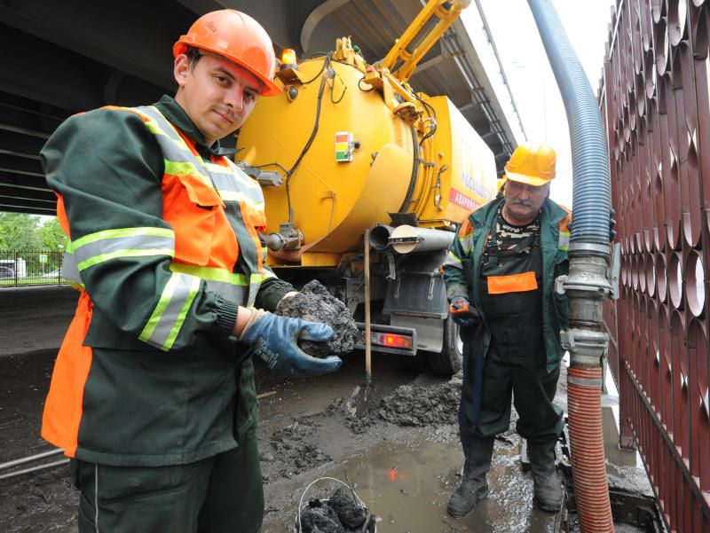 Сотрудники «Мосводостока» прочищают ливневую канализацию. Фото: Александр Кожохин, «Вечерняя Москва»